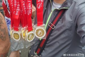 球迷在阿森納冠軍巡游賣獎牌，撕開貼紙寫著：利物浦是冠軍！